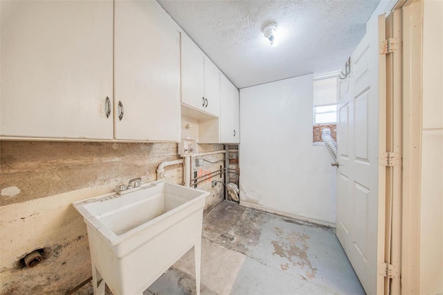 washroom with sink and a textured ceiling