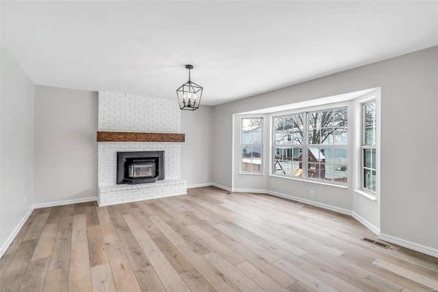 unfurnished living room with light hardwood / wood-style flooring and an inviting chandelier