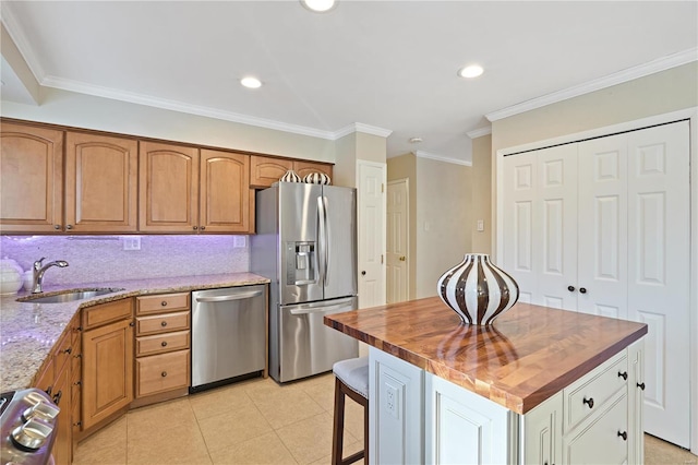 kitchen featuring butcher block countertops, sink, decorative backsplash, a center island, and stainless steel appliances