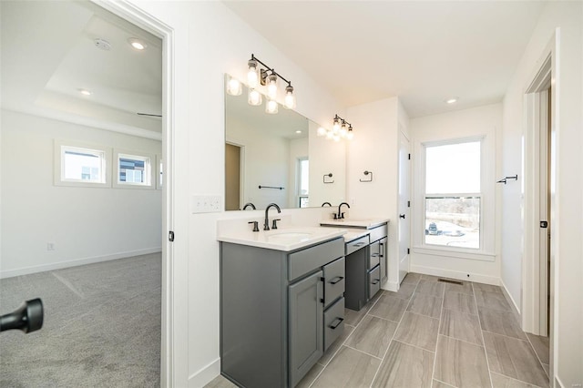 bathroom featuring a raised ceiling and vanity