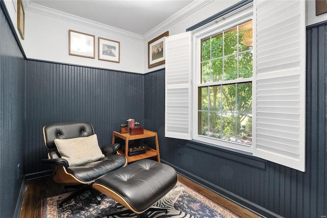 sitting room featuring a healthy amount of sunlight, wood-type flooring, and ornamental molding