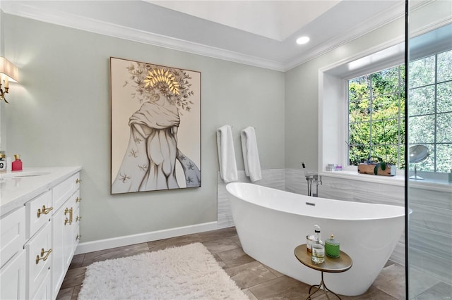 bathroom with crown molding, a bathtub, and vanity