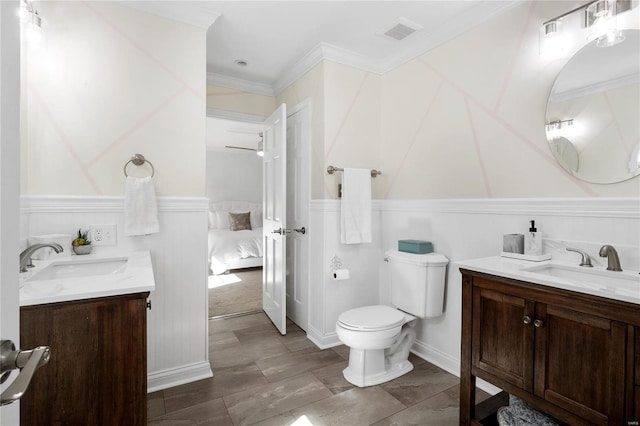 bathroom featuring toilet, ornamental molding, and vanity