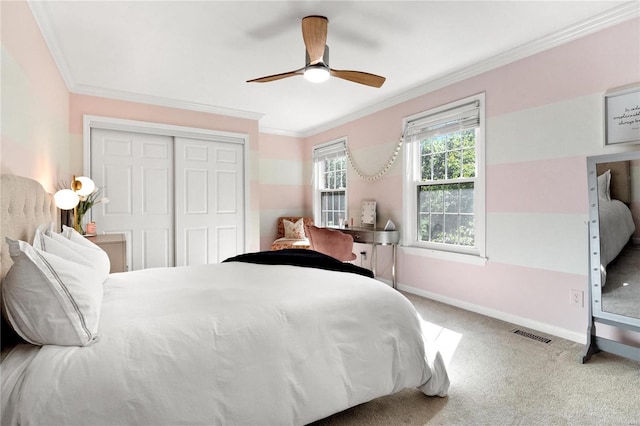 bedroom with ceiling fan, carpet, a closet, and ornamental molding