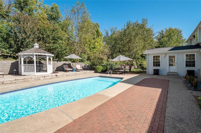 view of pool with a gazebo, an outbuilding, and a patio