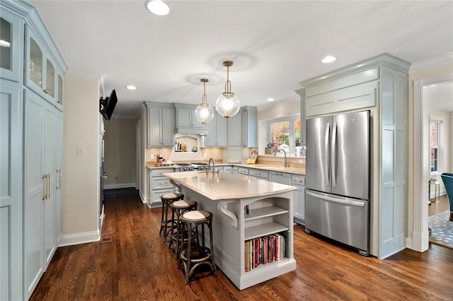 kitchen featuring pendant lighting, a kitchen island, dark hardwood / wood-style flooring, stainless steel refrigerator, and light stone counters