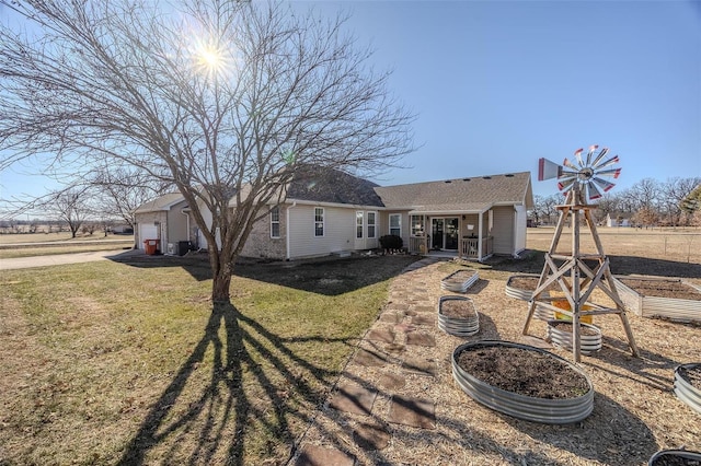 rear view of property featuring a garage and a lawn