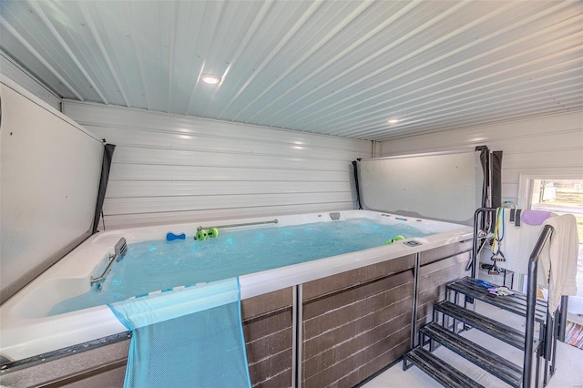 misc room with a jacuzzi and wood walls