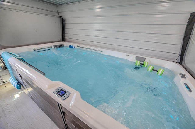 view of swimming pool featuring a hot tub