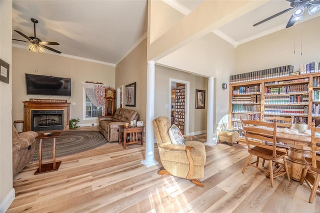 living area featuring ornate columns, ceiling fan, ornamental molding, and light wood-type flooring