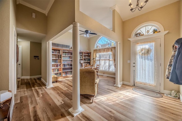 entryway with light wood-type flooring, a high ceiling, and ornate columns