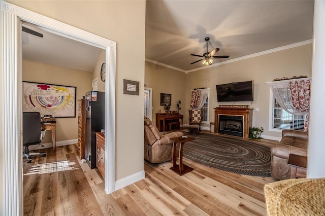 living room featuring ornamental molding, ceiling fan, and light hardwood / wood-style floors