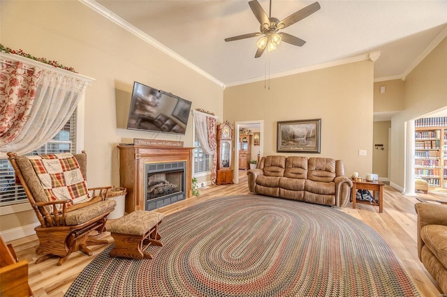 living room with crown molding, ceiling fan, and light hardwood / wood-style flooring