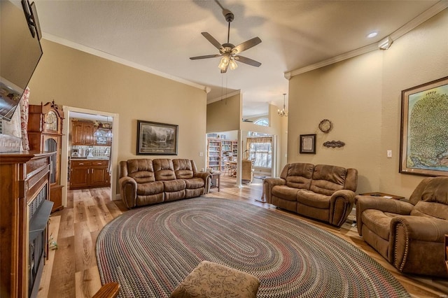 living room featuring crown molding, ceiling fan, and light wood-type flooring