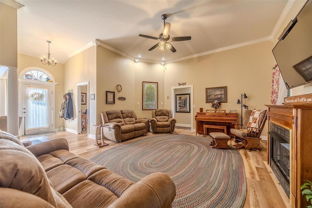 living room featuring crown molding, ceiling fan with notable chandelier, and light wood-type flooring