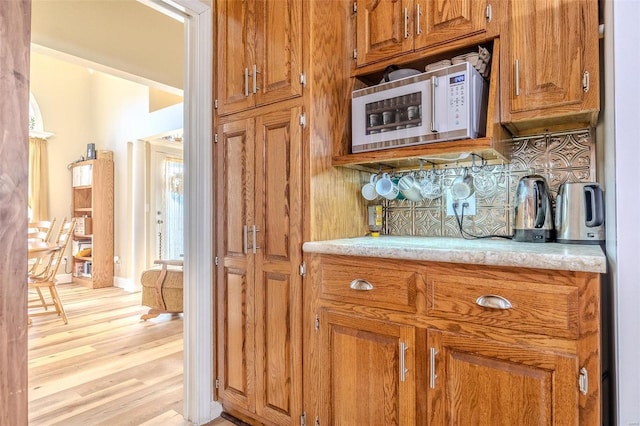 kitchen with tasteful backsplash and light hardwood / wood-style flooring