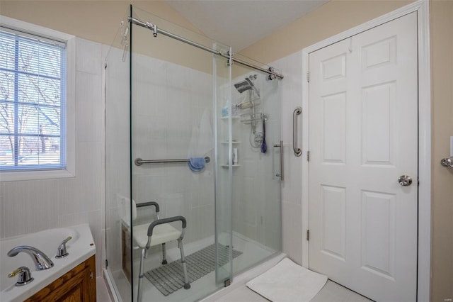 bathroom featuring a shower with door and vaulted ceiling