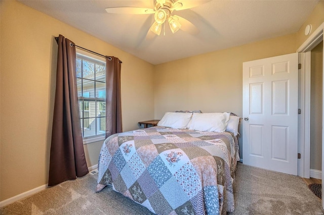 carpeted bedroom with ceiling fan and multiple windows