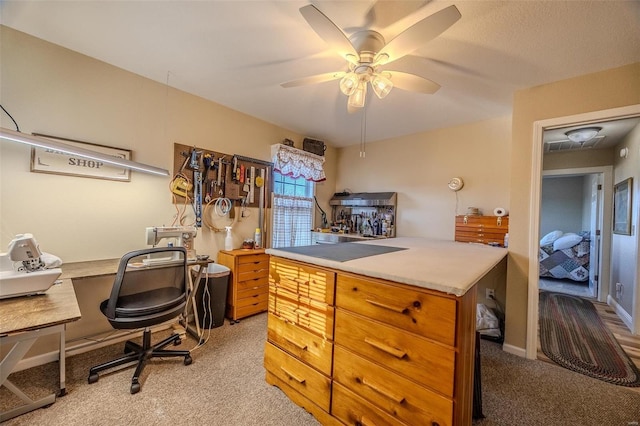 carpeted home office featuring ceiling fan