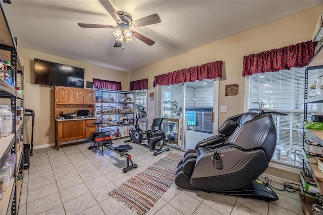 workout room featuring light tile patterned flooring, a textured ceiling, and ceiling fan