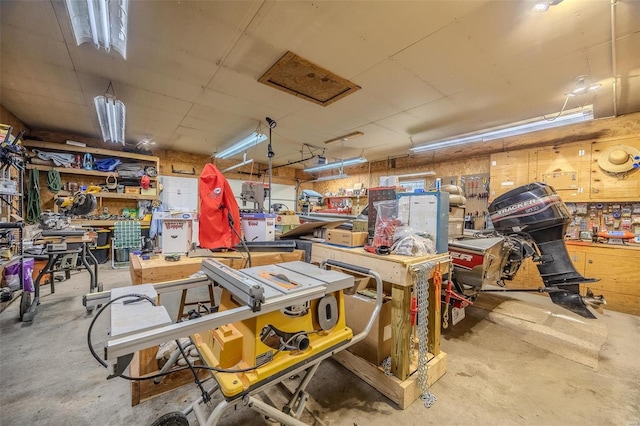 miscellaneous room with concrete flooring and a workshop area