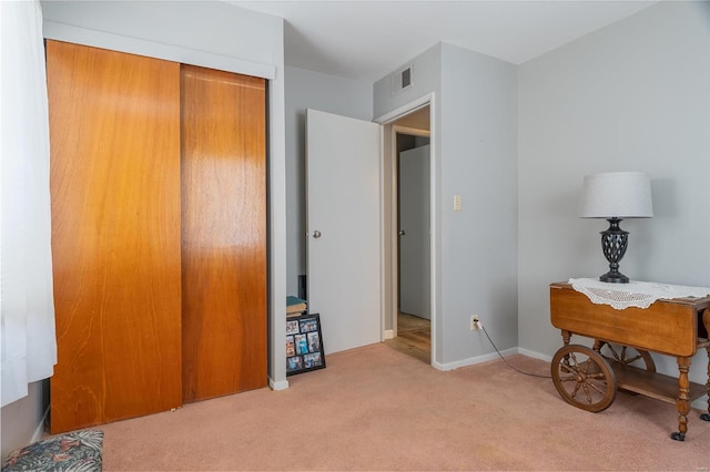 bedroom featuring light colored carpet and a closet