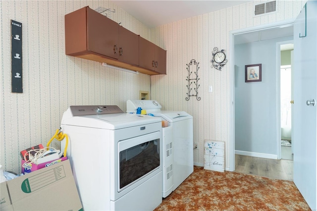 laundry room with washer and clothes dryer and cabinets