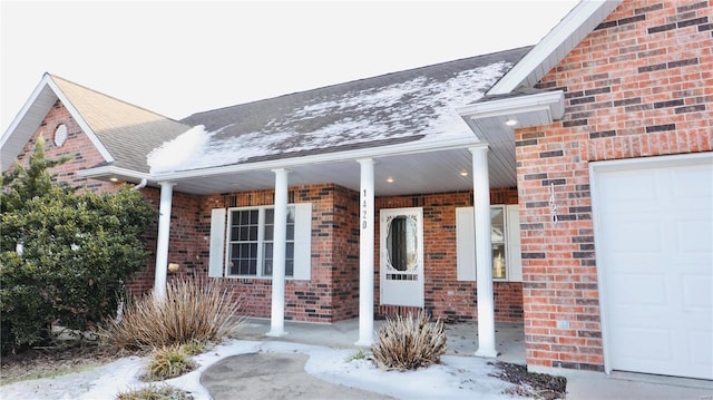 snow covered property entrance with covered porch