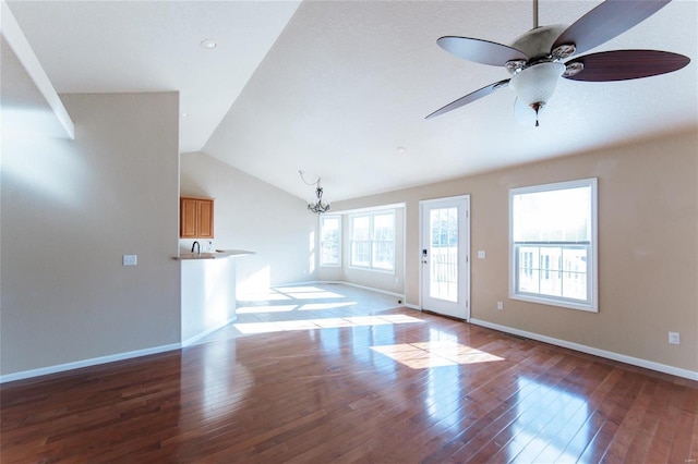 unfurnished living room featuring lofted ceiling, hardwood / wood-style flooring, and ceiling fan with notable chandelier