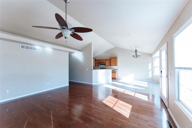 unfurnished living room with lofted ceiling, hardwood / wood-style flooring, a wealth of natural light, and ceiling fan with notable chandelier