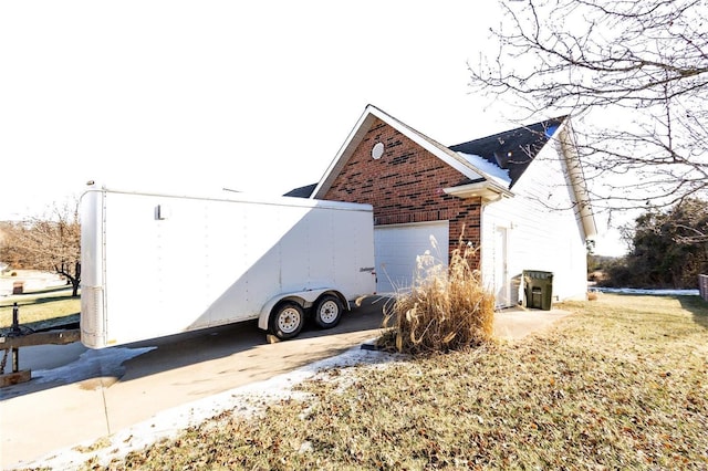 view of side of property featuring a garage and a yard