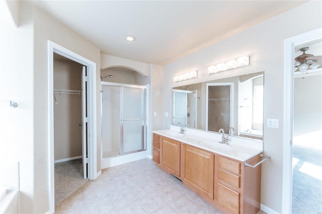 bathroom featuring ceiling fan, vanity, tile patterned flooring, and a shower with door