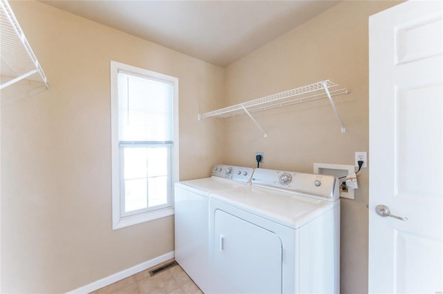 laundry room featuring washing machine and dryer and light tile patterned floors