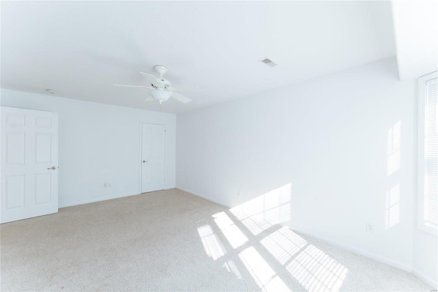 unfurnished room featuring light carpet and ceiling fan