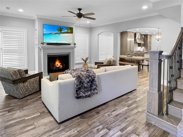 living room featuring crown molding, hardwood / wood-style floors, and ceiling fan