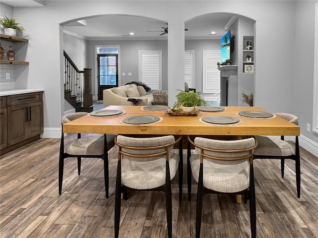 dining space featuring ceiling fan, ornamental molding, and wood-type flooring