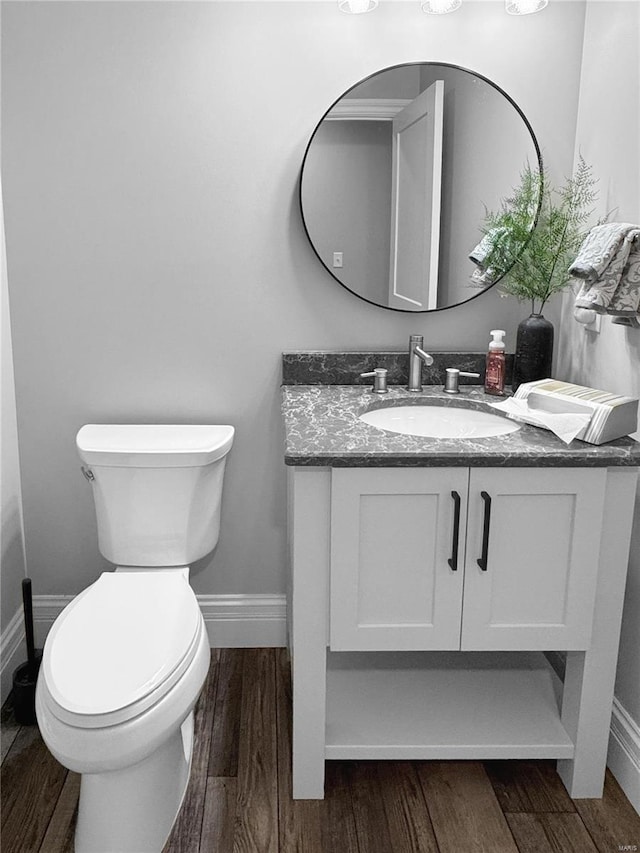 bathroom with hardwood / wood-style flooring, toilet, and vanity