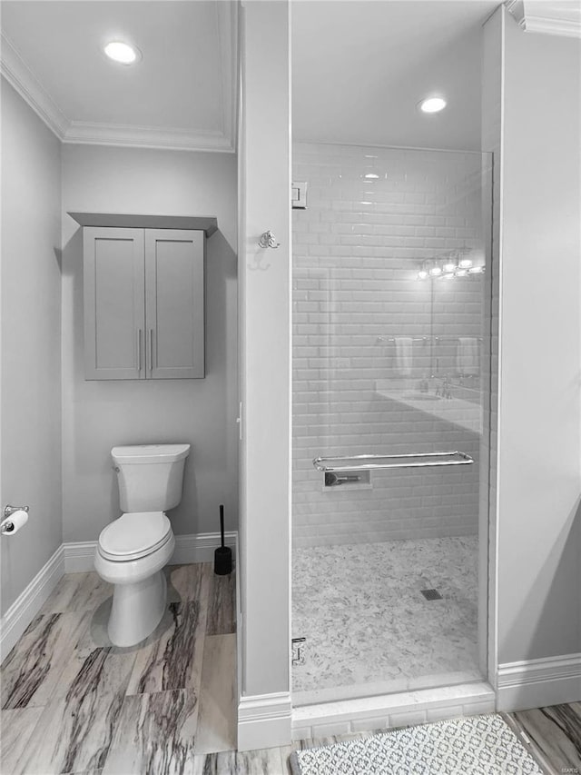 bathroom featuring tiled shower, ornamental molding, and toilet