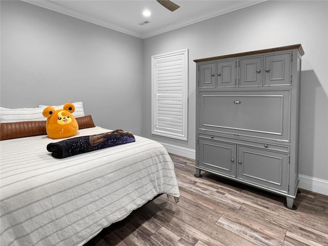 bedroom with crown molding, hardwood / wood-style floors, and ceiling fan