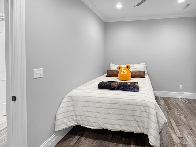 bedroom featuring hardwood / wood-style floors, ceiling fan, and ornamental molding