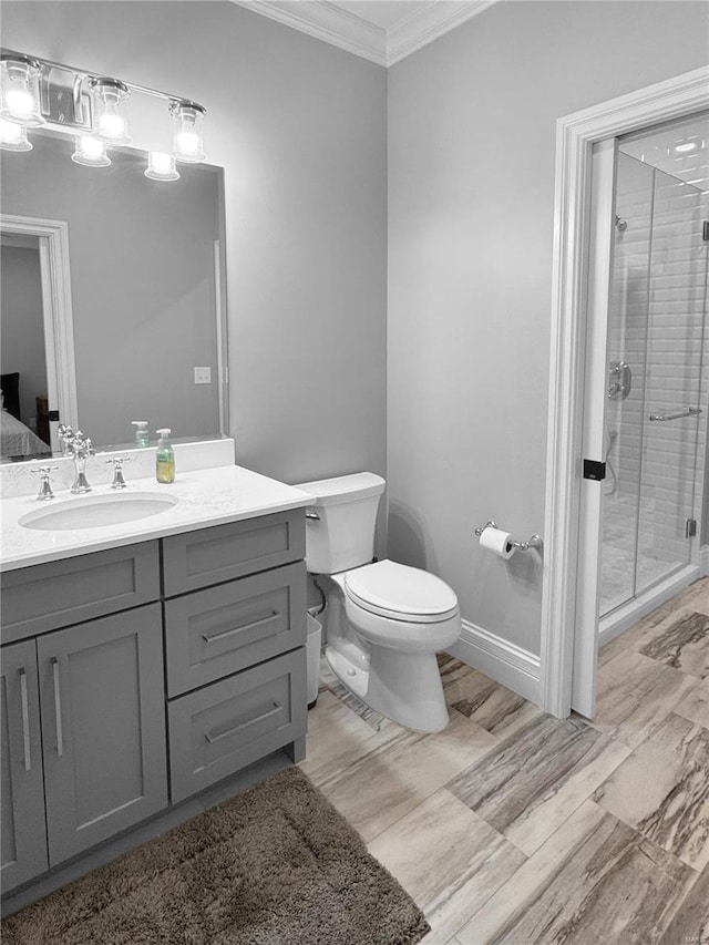 bathroom featuring a shower with door, toilet, vanity, and crown molding