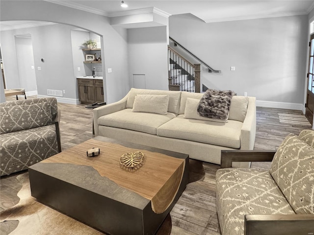 living room with crown molding and light hardwood / wood-style floors