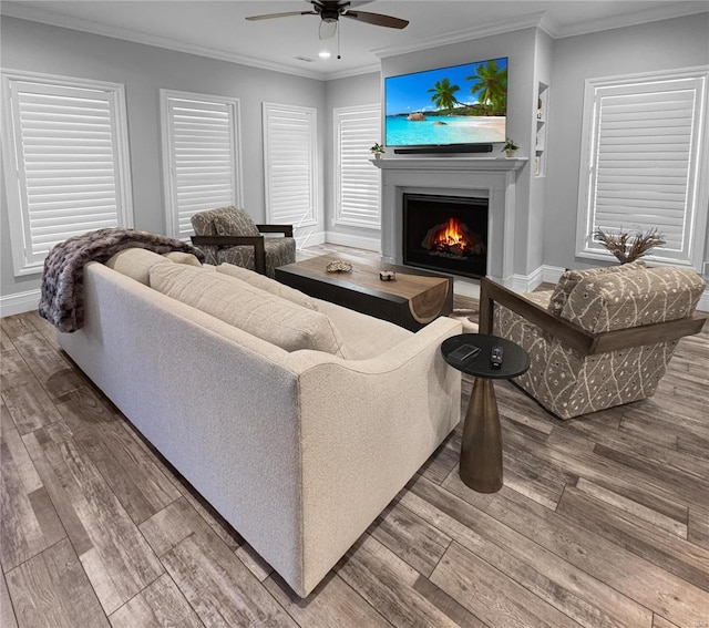 living room with ornamental molding, hardwood / wood-style floors, and ceiling fan