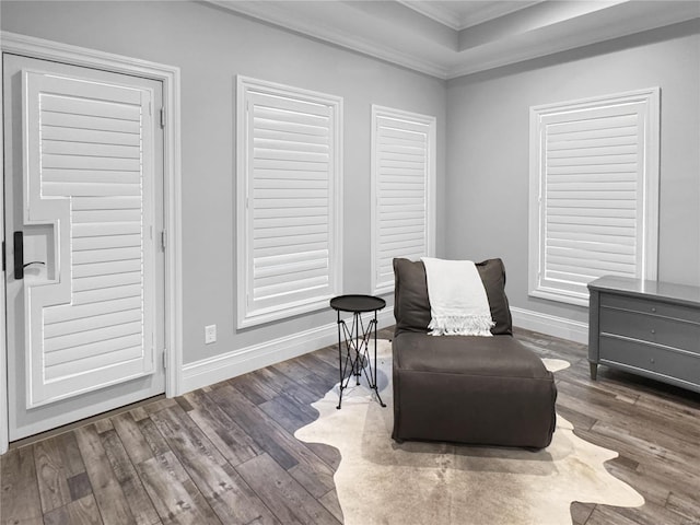 living area with ornamental molding, dark hardwood / wood-style flooring, and a tray ceiling