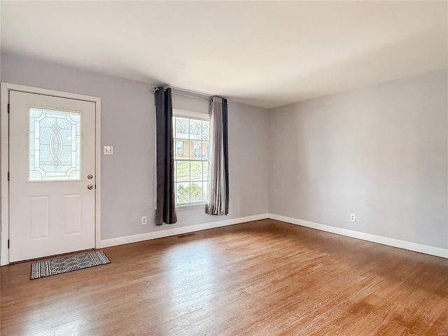 foyer with baseboards and wood finished floors