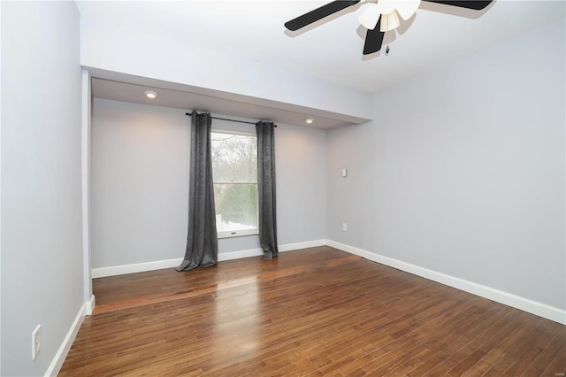 empty room with a ceiling fan, baseboards, and wood finished floors