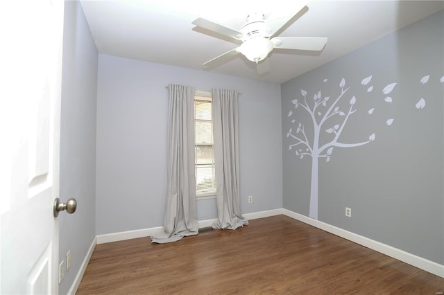 spare room with ceiling fan, baseboards, and wood finished floors