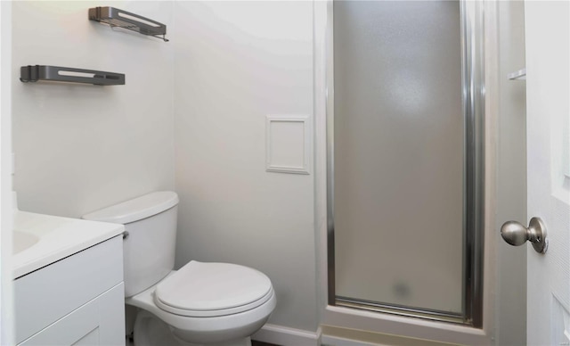 bathroom featuring toilet, a shower stall, and vanity