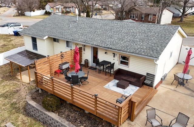 rear view of property with a shingled roof, fence, outdoor dining area, a deck, and an outdoor living space