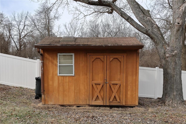 view of shed featuring fence